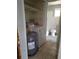 Incomplete bathroom/utility room featuring a water heater, washing machine, toilet, and bathtub at 7240 Donna Dr, New Port Richey, FL 34652