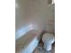 Close-up of a bathtub and toilet in a bathroom with damaged tile, highlighting the need for renovation at 7240 Donna Dr, New Port Richey, FL 34652