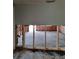 Large room undergoing renovation with exposed studs, insulation, and flooring partially removed, showing its potential at 7240 Donna Dr, New Port Richey, FL 34652