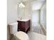 Modern bathroom with a dark wood vanity, toilet, and a view into the bedroom at 18019 Avonsdale Cir, Port Charlotte, FL 33948