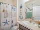 Charming bathroom with a single sink, nautical decor and a themed shower curtain at 5144 Flowing Oar Rd, Wimauma, FL 33598