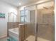Modern bathroom featuring a soaking tub and separate glass-enclosed shower, offering a spa-like experience at 5144 Flowing Oar Rd, Wimauma, FL 33598