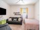 The bedroom features a ceiling fan, TV, couch and a bed for flexible options at 5144 Flowing Oar Rd, Wimauma, FL 33598
