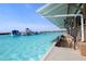 View of the pool with waterslides and a covered outdoor bar and seating area with tables along the edge of the pool at 5144 Flowing Oar Rd, Wimauma, FL 33598