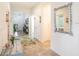 Bright and inviting hallway with tile flooring, leading to various rooms and the front door at 5144 Flowing Oar Rd, Wimauma, FL 33598