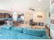 Spacious living area flowing into kitchen, featuring modern decor, tile flooring, and comfortable seating at 5144 Flowing Oar Rd, Wimauma, FL 33598