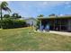 Lush backyard featuring a screened-in patio with comfortable seating and a well-manicured lawn at 119 Caddy Rd, Rotonda West, FL 33947
