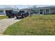 Well-maintained front yard with a paved driveway leading to a charming single-story home at 119 Caddy Rd, Rotonda West, FL 33947