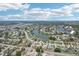 Aerial view of a residential area, showcasing homes along winding streets surrounding a small lake at 1301 Lucaya Ave, Venice, FL 34285