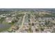 Aerial view of a residential area, showcasing homes along winding streets and a small lake at 1301 Lucaya Ave, Venice, FL 34285