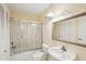 Bathroom with a tiled shower, white sink, toilet, and large mirror at 1301 Lucaya Ave, Venice, FL 34285