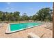Large community pool surrounded by lush greenery, lounge chairs, and brick patio at 1301 Lucaya Ave, Venice, FL 34285