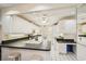 Bright kitchen with white cabinetry, black countertops, and white tile flooring at 1301 Lucaya Ave, Venice, FL 34285