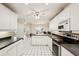 Modern kitchen with white cabinetry, tile floor and updated appliances at 1301 Lucaya Ave, Venice, FL 34285