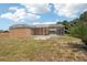 View of back of house with a screened in patio and grassy yard at 1301 Lucaya Ave, Venice, FL 34285