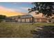 Enclosed patio with a lush lawn and vibrant sunset, offering a perfect outdoor retreat at 1301 Lucaya Ave, Venice, FL 34285