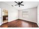 Comfortable bedroom with hardwood floors, ceiling fan, and access to the ensuite bathroom at 14174 Oakham St, Tampa, FL 33626