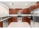 Modern kitchen boasting stainless steel appliances, granite countertops, and warm wood cabinetry at 14174 Oakham St, Tampa, FL 33626