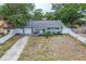 Aerial view of a charming single-story home with a blue exterior, an attached garage, and fenced perimeter at 2824 Oaklawn Ave, Largo, FL 33771