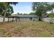 Backyard featuring a grey house, pavilion, sliding glass doors, and white vinyl fence at 2824 Oaklawn Ave, Largo, FL 33771