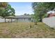 Backyard featuring a grey house, pavilion, sliding glass doors, and white vinyl fence at 2824 Oaklawn Ave, Largo, FL 33771
