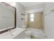 Bright bathroom features a tub and shower combo, neutral tile, and a large vanity mirror at 2824 Oaklawn Ave, Largo, FL 33771