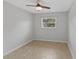 Bedroom featuring tile flooring, ceiling fan, and window; features neutral walls at 2824 Oaklawn Ave, Largo, FL 33771