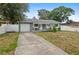 Charming single-story home with a blue exterior, well-maintained landscaping, and an attached garage at 2824 Oaklawn Ave, Largo, FL 33771