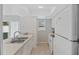 Galley kitchen with white cabinets and appliances, neutral countertops and double stainless sink at 2824 Oaklawn Ave, Largo, FL 33771