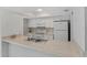 Bright kitchen featuring white cabinets, stainless sink, and neutral countertops at 2824 Oaklawn Ave, Largo, FL 33771