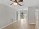 Open-concept living room with neutral walls, tile floors, modern ceiling fan, and sliding glass doors to backyard at 2824 Oaklawn Ave, Largo, FL 33771