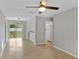 Open-concept living room with neutral walls, tile floors, modern ceiling fan, and sliding glass doors to backyard at 2824 Oaklawn Ave, Largo, FL 33771