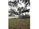 Spacious backyard with a large tree providing shade and a trampoline for recreation at 3628 Nettle Creek Ct, Holiday, FL 34691