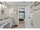 Bathroom featuring double sinks, granite countertop, updated fixtures, and access to bedroom at 4605 Steel Dust Ln, Lutz, FL 33559