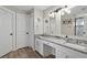 Bathroom featuring double sinks, granite countertop, updated fixtures, and a subway tile shower at 4605 Steel Dust Ln, Lutz, FL 33559