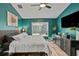 Stylish bedroom featuring hardwood floors, a large window overlooking the backyard, and blue accent wall at 4605 Steel Dust Ln, Lutz, FL 33559