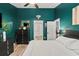 Stylish bedroom featuring hardwood floors, a black dresser, and green accent wall at 4605 Steel Dust Ln, Lutz, FL 33559
