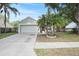 Charming single-Gathering home with a well-maintained lawn, mature palm trees, and a two-car garage at 4605 Steel Dust Ln, Lutz, FL 33559