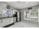 Well-lit eat-in kitchen featuring stainless steel appliances, granite countertops, and pristine marble floors at 4605 Steel Dust Ln, Lutz, FL 33559