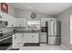 Modern kitchen featuring white cabinets, granite countertops, stainless steel appliances, and marble floors at 4605 Steel Dust Ln, Lutz, FL 33559