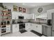 Bright kitchen with white cabinets, granite countertops, stainless steel appliances, and sleek marble floors at 4605 Steel Dust Ln, Lutz, FL 33559