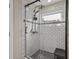 Bathroom featuring subway tile shower with black hardware and unique patterned floor at 4605 Steel Dust Ln, Lutz, FL 33559