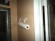 Bathroom wall featuring a toilet paper holder and decorative framed mirror at 11511 Misty Isle Ln, Riverview, FL 33579