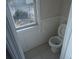 Tight space featuring a toilet, small window, and worn finishes at 11511 Misty Isle Ln, Riverview, FL 33579