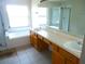 Bathroom featuring a tiled floor, double sinks, bathtub and shower at 11511 Misty Isle Ln, Riverview, FL 33579