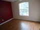 A room with laminate floor, white ceiling fan, and red accent wall at 11511 Misty Isle Ln, Riverview, FL 33579