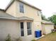 Beige home featuring stucco siding with multiple windows and garbage cans at 11511 Misty Isle Ln, Riverview, FL 33579