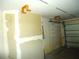 Bright garage space featuring an open wall ready for drywall, with shelving for storage at 11511 Misty Isle Ln, Riverview, FL 33579