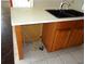 Image of a kitchen sink with wooden cabinets below, with exposed pipes and wiring at 11511 Misty Isle Ln, Riverview, FL 33579