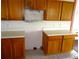 Image of a kitchen counter with wood cabinets above and below, and tile flooring at 11511 Misty Isle Ln, Riverview, FL 33579